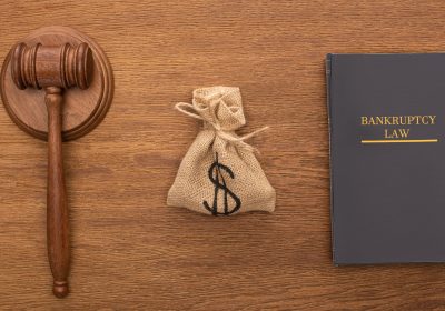 top view of bankruptcy law book, money bag and gavel on wooden background top view of bankruptcy law book, money bag and gavel on wooden background